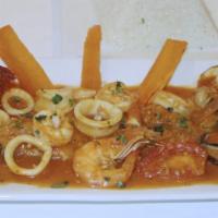 Pescado A Lo Macho · Fried fish fillet topped with seafood in hot yellow pepper sauce, served with rice and yuccas.