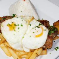 Churrasco A Lo Pobre · NY strip steak served with fried eggs, sweet plantains, fries, and rice.