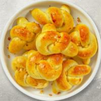 Naughty Garlic Knots · A classic Italian pizzeria snack, garlic knots are strips of pizza dough tied in a knot, bak...
