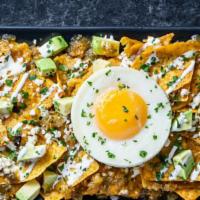 Chilaquiles · Tortillas chips simmered in salsa roja topped with queso fresco, crèma, avocado, and a sunny...