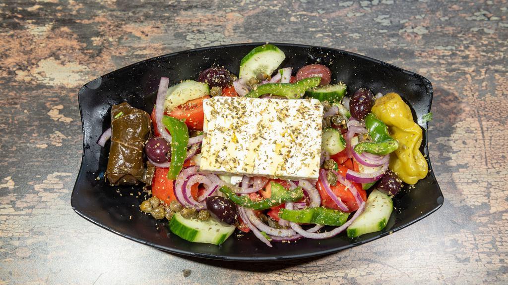 Horiatiki · Vegetarian.Fresh tomatoes, cucumbers, red onions, imported feta cheese, Kalamata olives, Green peppers, stuffed grape leaves, pepperoncini and capers with extra virgin olive oil & red wine vingegar. Served with pita bread.