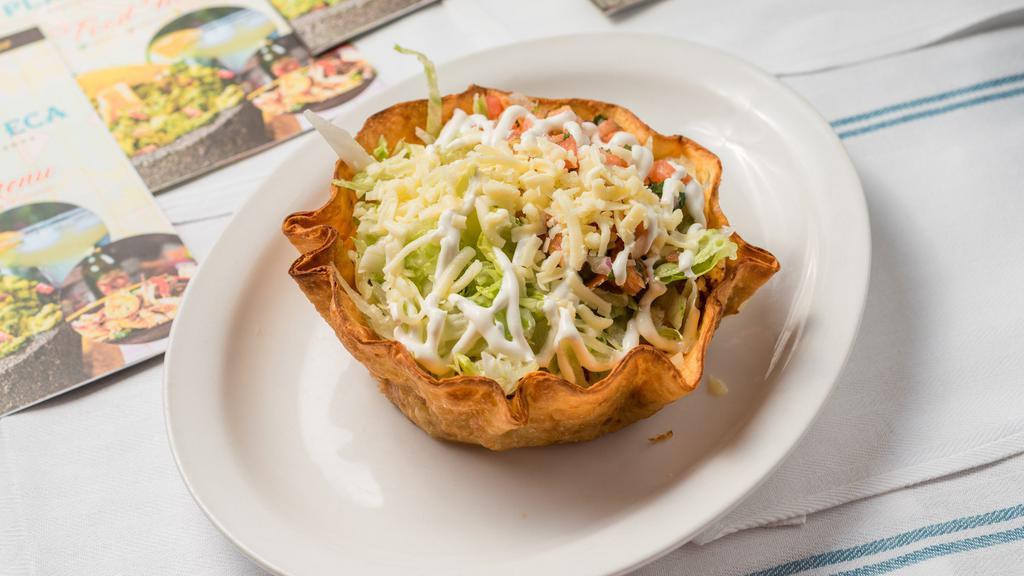 Taco Salad · Flour tortilla bowl filled with beans, lettuce, pico de gallo, cheese, sour cream and your choice of ground beef or shredded chicken.