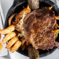 Molcajete Azteca · A traditional feast! A hot volcanic stone bowl filled with a juicy rib-eye steak, chicken br...