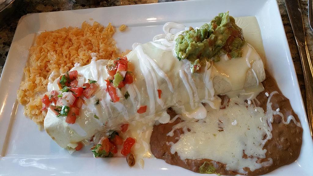 Burrito Mex · Recommended. One ten inch flour tortilla filled with your choice of grilled steak or chicken, onions and beans topped with guacamole dip pico de gallo and sour cream. Served with a side of rice and beans. 660 calories.
