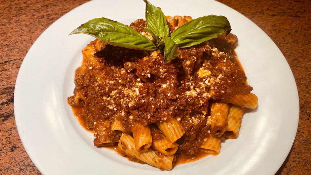 Rigatoni Bolognese · Rigatoni pasta tossed with our zesty meat sauce and finished with grated Parmesan cheese.