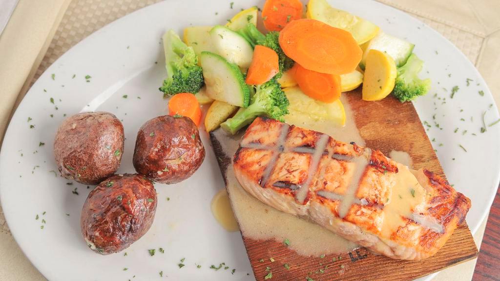 Wood Grilled Salmon · Grilled on a cedar plank topped with lemon butter sauce, served with house vegetables and garlic red potatoes.