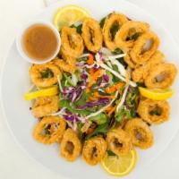 Our Famous Sesame Calamari Salad · Asian greens, miso ginger dressing, peanut sauce, scallions and sesame seeds.