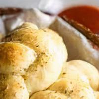 Garlic Knots · 5 pieces of thinly knotted pizza dough rolls baked golden brown and soaked in fresh garlic a...