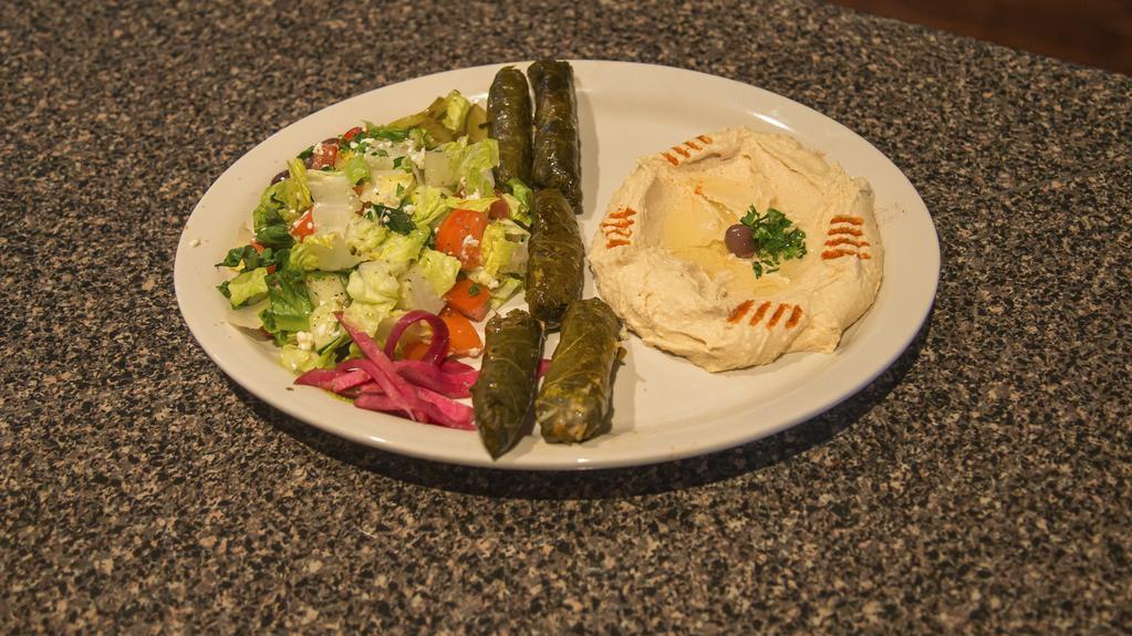 Dolma Plate · Grape leaves roll stuffed with beef and rice. Comes with hummus and Greek salad and pita on the side