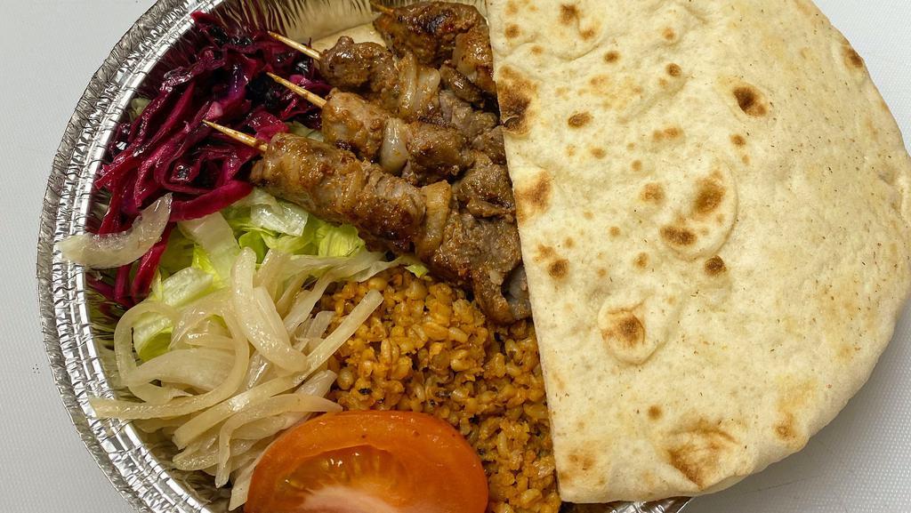 Lamb Shish Kebab Platter · Grilled lamb meat served with rice, lettuce, purple salad, tomato and pita bread.