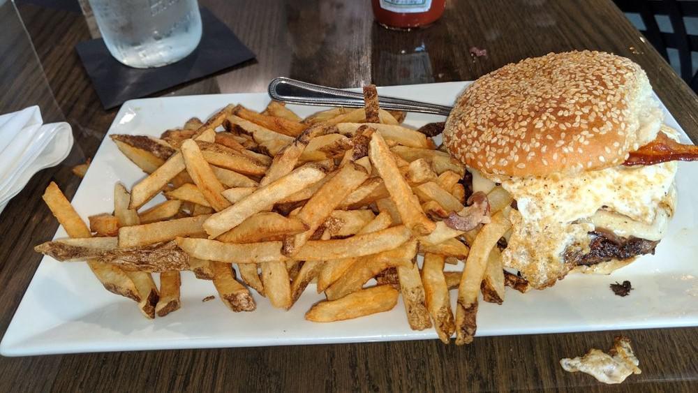 The Classic Burger · 8 oz Black Angus Beef Patty topped with red onion, lettuce, tomato, and American cheese, served on a brioche bun.