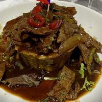Mofongo De Carne · Mashed green plantains topped with steak.