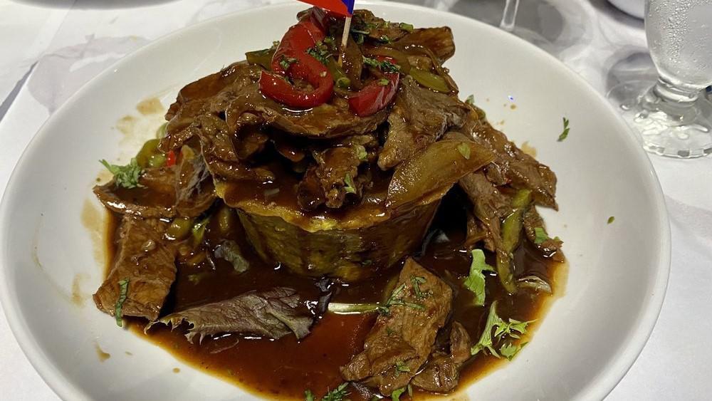 Mofongo De Carne · Mashed green plantains topped with steak.
