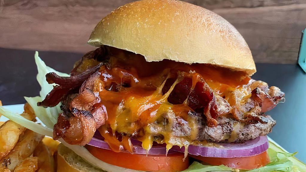 Texas Burger · Our Texas burger is served on a toasty bun and topped with cheddar, bacon, a southern style BBQ sauce, served with raw onion, lettuce, tomato, pickle.
