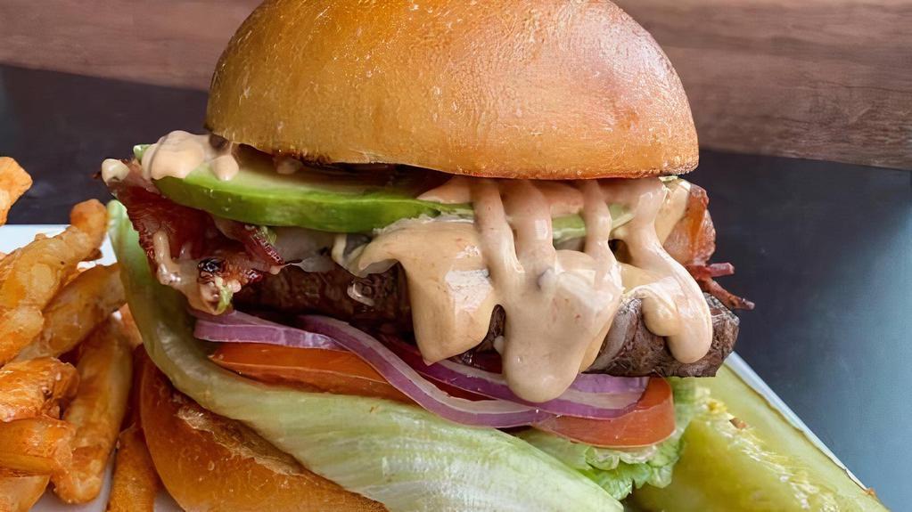 Chipotle Burger · Our chipotle burger is served on a toasty bun and topped with avocado, Monterrey jack cheese, bacon, a special chipotle sauce, raw onion, lettuce, tomato, pickle.