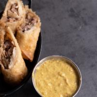 Pastrami Egg Rolls · Strips of pastrami sautéed with cabbage and onions served with a horseradish mustard.