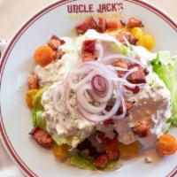 Iceberg Wedge Salad · Red onions, bacon, tomatoes, stilton blue cheese crumbles, blue cheese dressing.