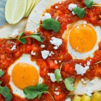 Huevos Rancheros · Three eggs over a corn tortilla, spicy sauce, and jalapeno with onions. With tortillas and b...