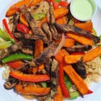 Steak Fajita Saltado · Sauteed flank steak, green peppers, onions, and sweet potatoes served over brown rice with a...