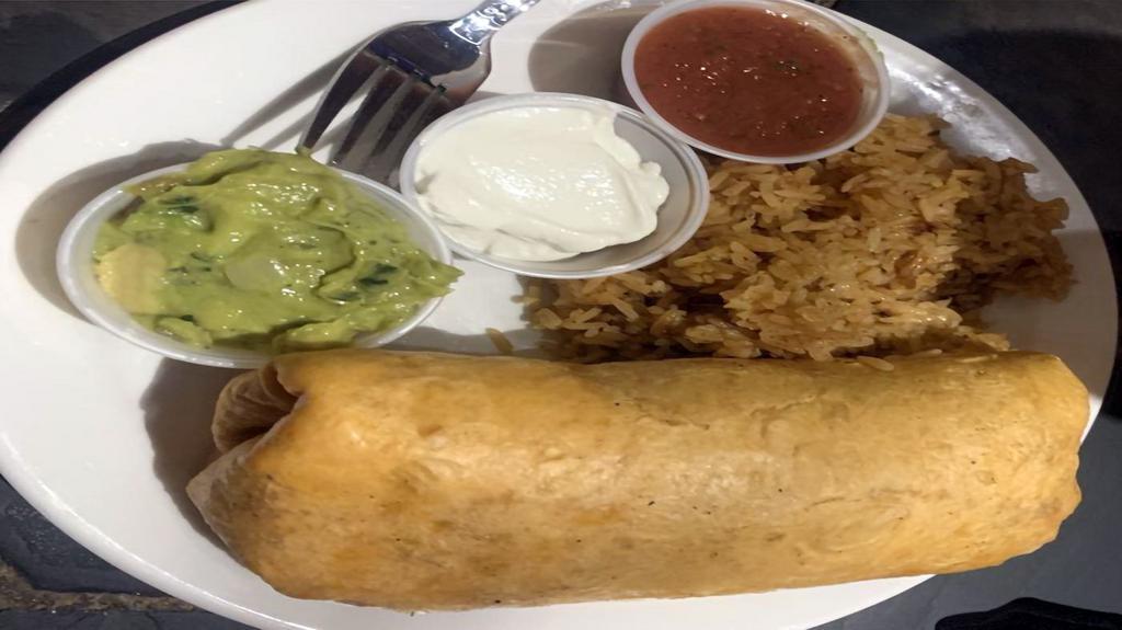 Breakfast Burrito · Eggs, Jack & cheddar cheese, black beans, onion, bell pepper, tomato, & chorizo wrapped in a tomato tortilla. Served with a side of Spanish rice, guacamole, sour cream, and homemade salsa.
