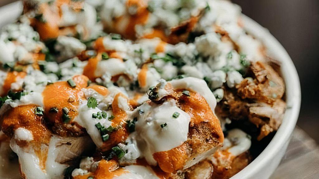 Buffalo Chicken Loaded Fries · Haus cut fries, spicy  buffalo dipped fried chicken, blue cheese sauce, blue cheese crumbles, chives