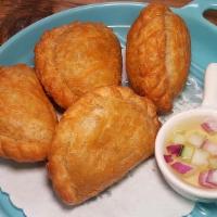 Curry Puff (4) · Savory pastry pockets stuffed with curried chicken, potatoes and onions.