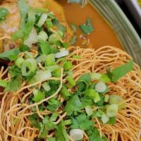 Khao Soi · Northern Thai style curry noodle soup with chicken drum stick, pickle, red onion, dried chil...