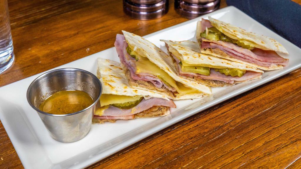 Cuban Quesadilla · Sliced Ham, pulled pork, melted swiss, pickles, mustard, and mojo sauce in a flour tortilla