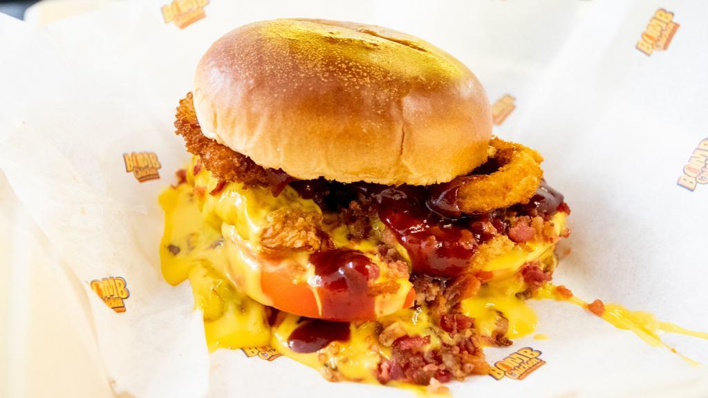 Nuclear Bacon · Quarter pound of handcrafted chicken tenders, onion rings, tomatoes, bacon, tangy BBQ sauce, Cheddar cheese on a toasted brioche bun.