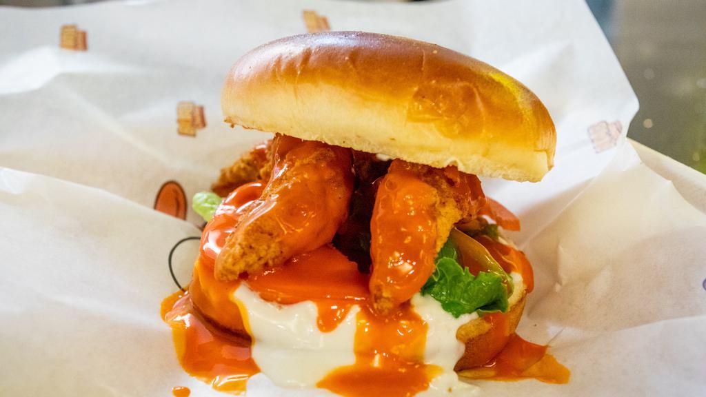 The Blue Torpedo · Quarter pound of handcrafted chicken tenders, lettuce, tomatoes, buffalo sauce and blue cheese sauce on a toasted brioche bun.