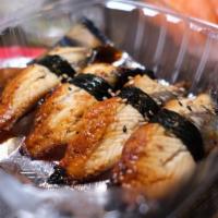 Unagi Don · Grilled eel with sauce over sushi rice and seaweed salad, oshinko, and sesame seed.