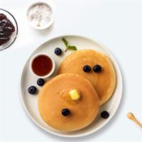 Berry Nut Pancakes · Three pancakes loaded with blueberry and almonds.