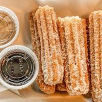 Churros · Churros coated with sugar and cinnamon with cinnamon and chocolate dipping sauces.