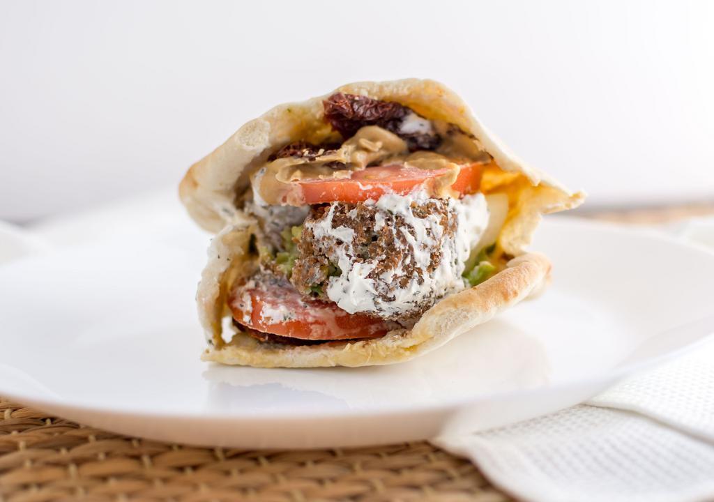 Falafel Sandwich · Vegetarian. Falafel, lettuce, tomato, sun dried tomato, hummus, tahini and tzatziki sauce on a wrap.