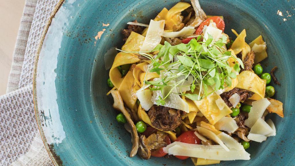 Braised Short Rib Pappardelle · Parmigiano Reggiano, grape tomatoes, peas, oyster mushrooms, shallots and truffle oil in a short rib ragu