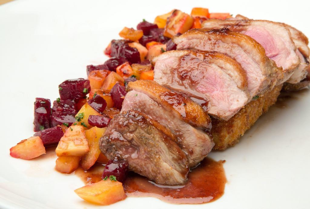 Long Island Duck · Coriander crusted duck breast, mixed root vegetables, crispy polenta cake and an apple pomegranate sauce.