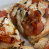 Bruschetta · Homemade Italian bread topped with tomatoes and basil garnished with parmigiano cheese.