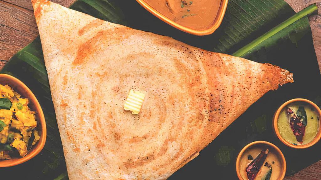 Mysore Masala Dosa · Rice crepe with layer of hot chutney filled with potatoes and onions. Served with sambhar, coconut and garlic chutney