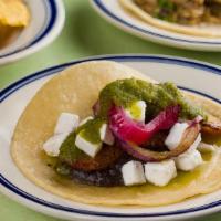 Plantain Taco · Sweet plantains with vegan feta, black beans, salsa verde & pickled red onions