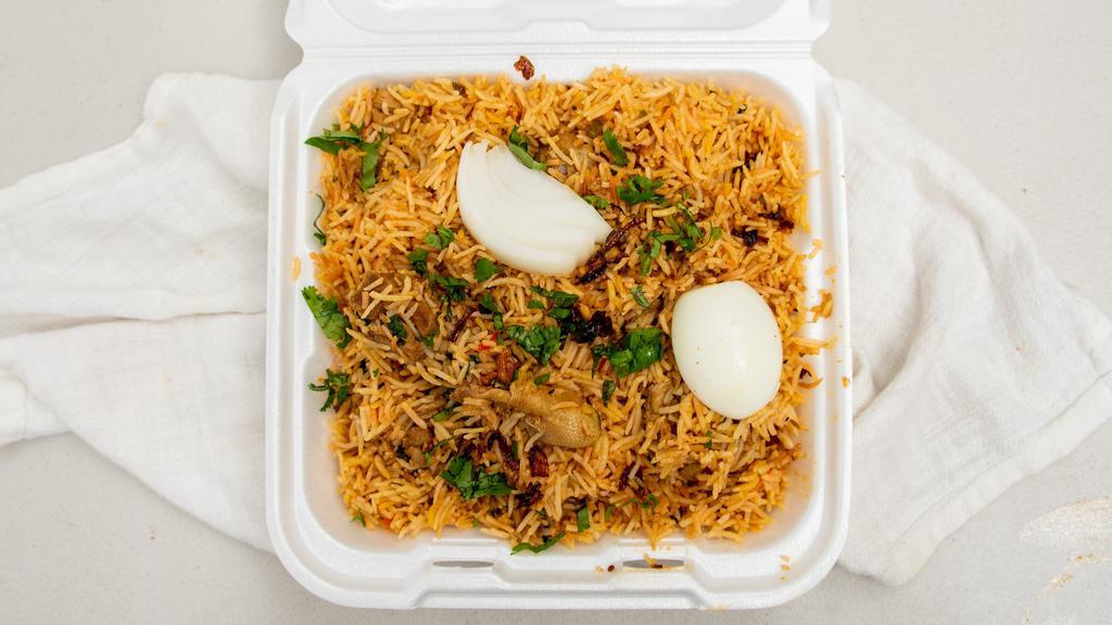 Chicken Dum Biryani · Long-grained rice flavored with exotic spices, layered with chicken, garnished with fried onion and egg.