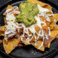 Nachos Con Carne · Chips, Refried Beans, Sour Cream, Cotija Cheese, with a Choice of Meat