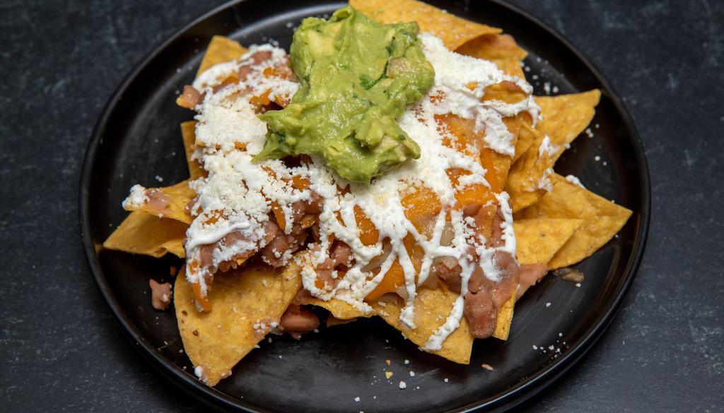 Nachos Con Carne · Chips, Refried Beans, Sour Cream, Cotija Cheese, with a Choice of Meat