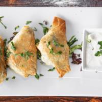 Spanakopita · phyllo pastry with spinach, dill, homemade feta, and lemon. served with tzatziki sauce.