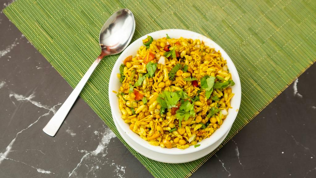 Bhel Puri · Bombay style mix of puffed rice, crispy sev, rice flour crisps, peanuts, onions, tomatoes, tangy & spicy chutney topped with cilantro.