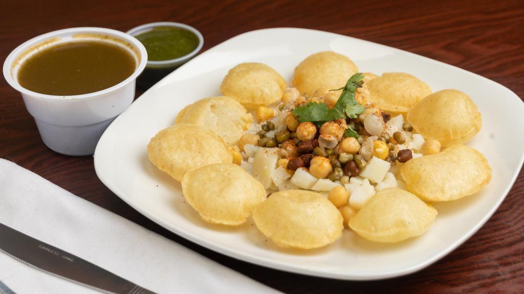 Pani Poori · Crispy pooris. Served with spiced potatoes, moong, chutney, and spiced water.