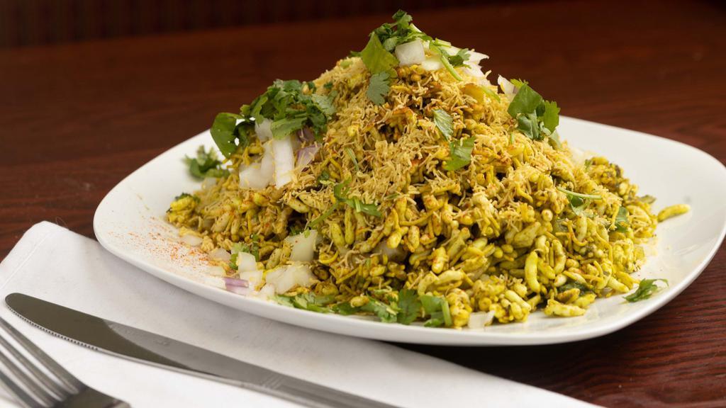 Bhel Poori · Crispy rice puffs topped with onions, potatoes, chutney, and spices.