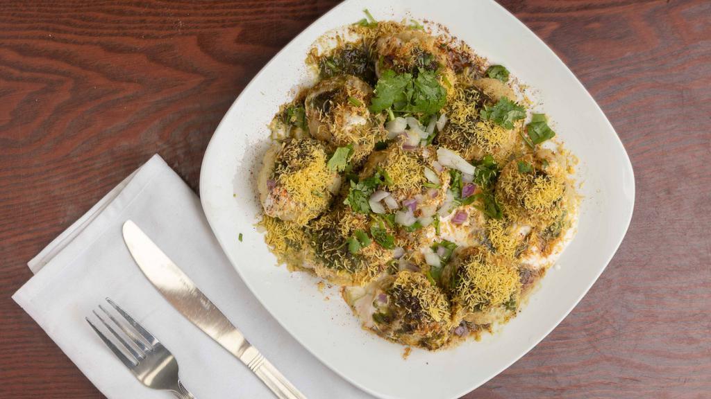 Dahi Batata Poori · Crispy pooris topped with onions, potatoes, yogurt, chutney, and spices.