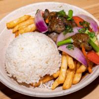 Steak Stir-Fry (Lomo Saltado) · Sliced beef chunks sautéed with red onions & tomatoes, served over rice and  french fries