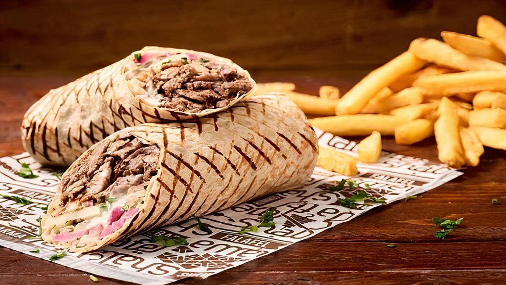Lamb Secret Shawarma · Thinly sliced lamb and beef mix wrapped in pita bread with lettuce, tomatoes, onions, pickles, and tahini sauce.