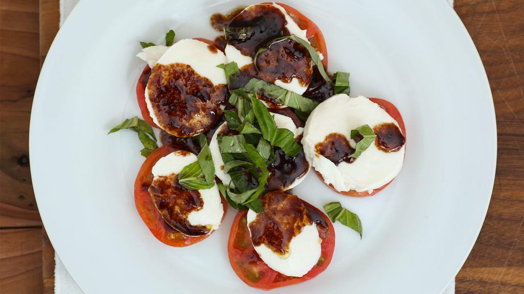 Caprese Salad · Fresh sliced buffalo mozzarella, tomato, and fresh basil in a balsamic vinaigrette dressing.